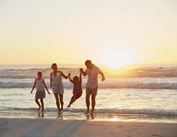 family on beach at sunset